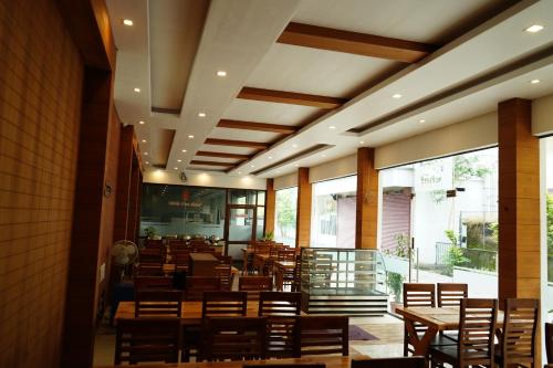 a dining room with wooden tables and chairs at The Patio Thekkady in Thekkady