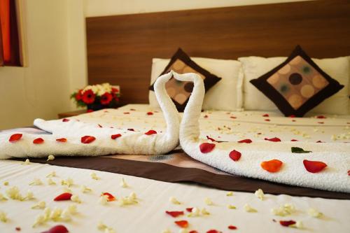 two swan towels on two beds with hearts on them at The Patio Thekkady in Thekkady
