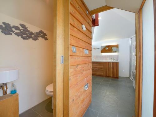 a bathroom with a wooden wall with a toilet at 3 Newhall Green in Delabole