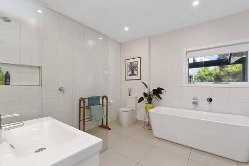 a white bathroom with a tub and a sink at Mirimar in Apollo Bay