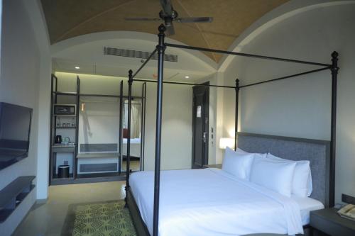 a bedroom with a white bed with a black frame at Radisson Resort & Spa Kandla in Gandhidham