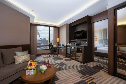 a living room with a couch and a table at The Landmark Bangkok in Bangkok