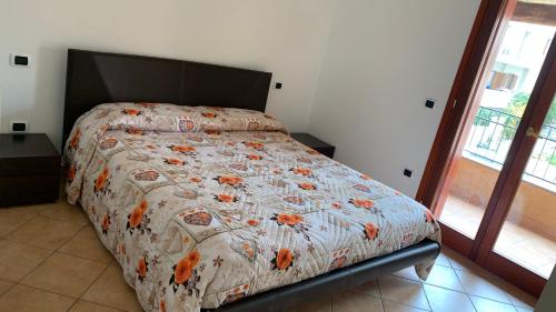 a bedroom with a bed with a comforter on it at Casa Sofia vista porto in Olbia