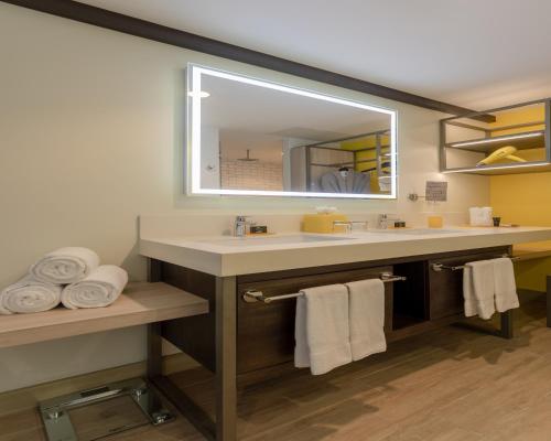 uma casa de banho com lavatório, espelho e toalhas em Hyatt Centric San Salvador em San Salvador