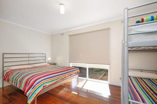a bedroom with a bunk bed and a window at Beach Fig in Apollo Bay