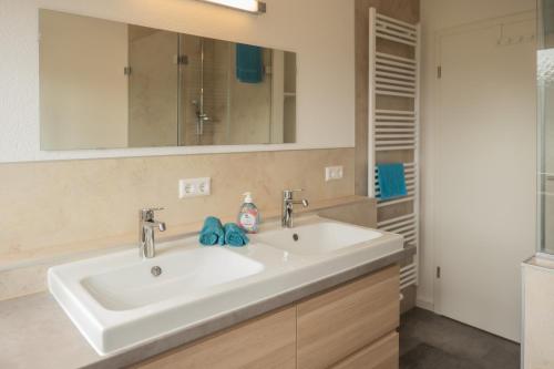 ein Badezimmer mit einem weißen Waschbecken und einem Spiegel in der Unterkunft Ferienwohnungen-Oberkochen.de Stadtherberge Sperberstraße in Oberkochen
