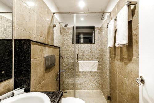 a bathroom with a shower with a toilet and a sink at Saaral Residency in Chennai