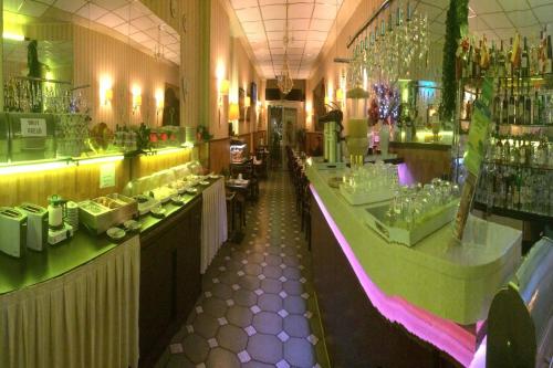 a restaurant with a long bar in a room at Apollo in Frankfurt