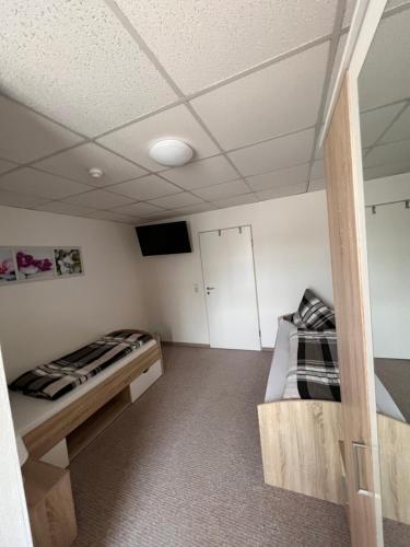 a room with two beds and a tv in it at Gäste & Seminarhaus Harz in Ballenstedt