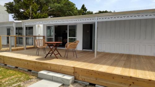 a deck with a table and chairs on a house at Hanamuro Inn Aka Island in Zamami
