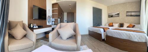 a hotel room with two beds and a tv at Apec Tuy Hoà Phú Yên in Liên Trì (3)