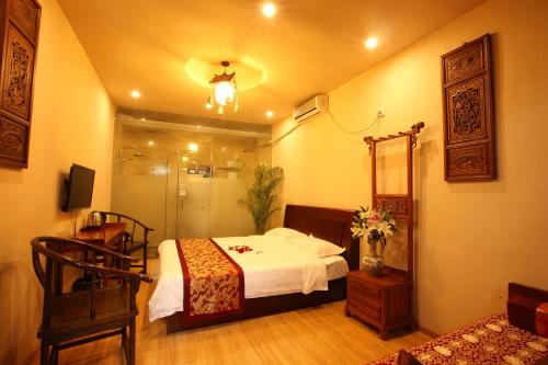 a bedroom with a bed and a shower and a mirror at Beijing Yue Bin Ge Courtyard Hotel in Beijing