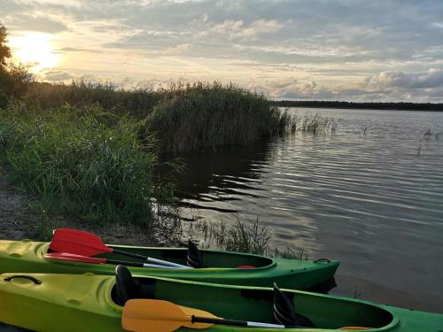 three canoes sitting on the shore of a lake at Sea2 in Nowęcin