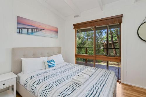 a white bedroom with a bed and a window at Villa Zara in Marengo