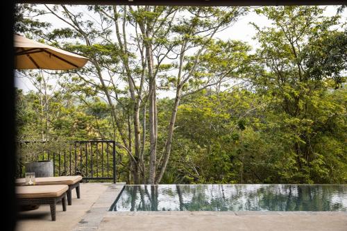 a swimming pool with a table and an umbrella at Kahanda Kanda in Koggala