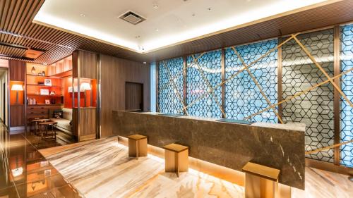 a lobby with a large glass wall with a counter at Via Inn Prime Nihonbashi Ningyocho in Tokyo