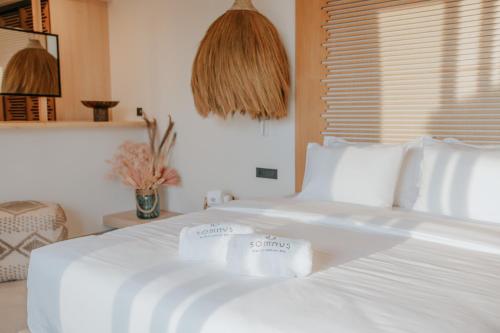 a white bed with two folded towels on it at Somnus Suites Parga in Parga