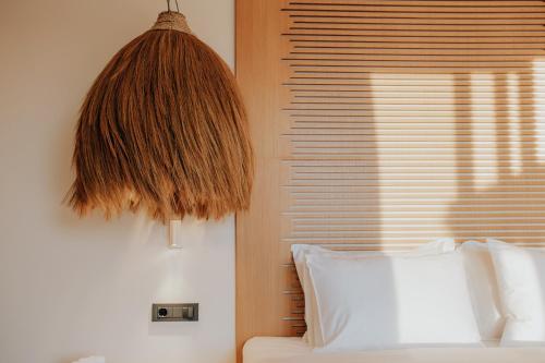 a bedroom with a bed and a window with a pendant at Somnus Suites Parga in Parga