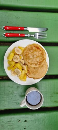 un piatto di cibo con frittelle e frutta su un tavolo di Twin Fin Plaza a Bocas del Toro