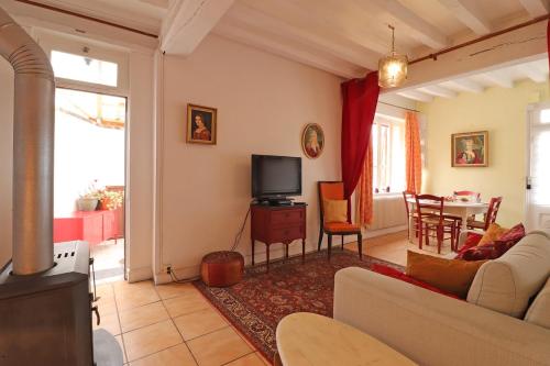 un salon avec un canapé et une télévision dans l'établissement La Petite Venise, à Longny-au-Perche