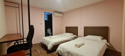a room with two beds and a desk and a mirror at Misto Hotel in Kota Kinabalu