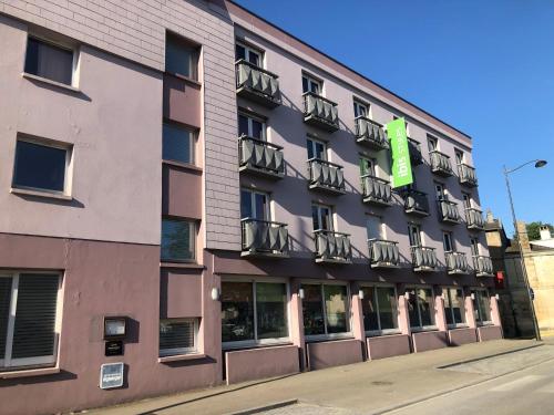 a building with a green sign on the side of it at ibis Styles Saint Dizier in Saint-Dizier
