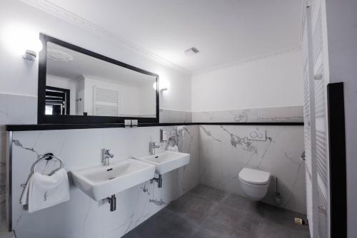 a bathroom with a toilet, sink, and mirror at Villa Conti in Český Krumlov