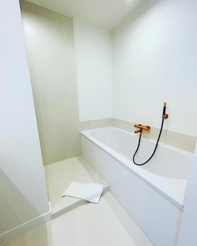 a white bathroom with a bath tub with a faucet at Hotel Bell-X Kortrijk-Wevelgem in Wevelgem