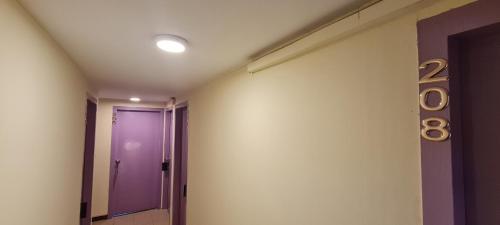a hallway with a purple door in a room at Misto Hotel in Kota Kinabalu