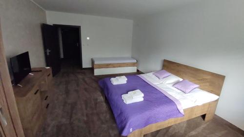 um quarto com uma cama com duas toalhas em GÓL CENTRUM RESORT em Sabinov