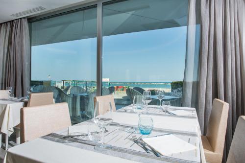a dining room with a table and a large window at Hotel Savini in Bellaria-Igea Marina