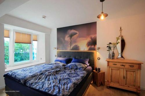 ein Schlafzimmer mit einem Bett und einem Wandgemälde in der Unterkunft FeWo Prora - Njoerd in Binz