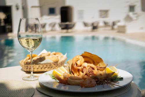 a plate of food next to a glass of wine at La Residenza Capri in Capri