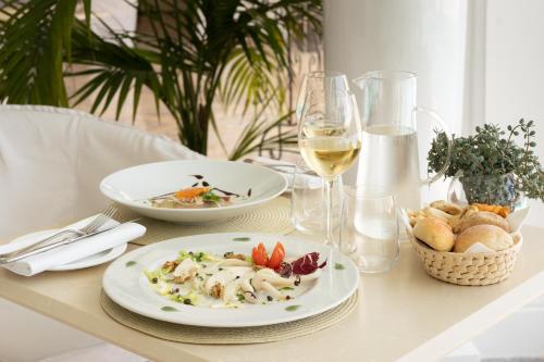 a table with two plates of food and a glass of wine at La Residenza Capri in Capri