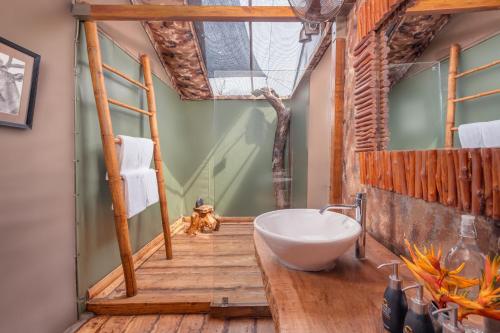 a bathroom with a large white bowl sink in a wooden floor at Leopard Safaris Yala in Yala
