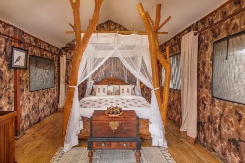 a bedroom with a bed in a room with logs at Leopard Safaris Yala in Yala