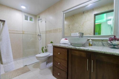 y baño con lavabo, aseo y ducha. en Room in Guest room - Cozy 1bd with common Jacuzzi, en Sosúa