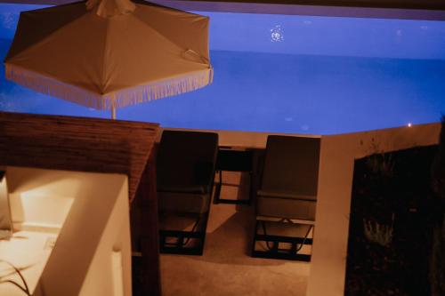 a table and chairs under a blue aquarium at Somnus Suites Parga in Parga