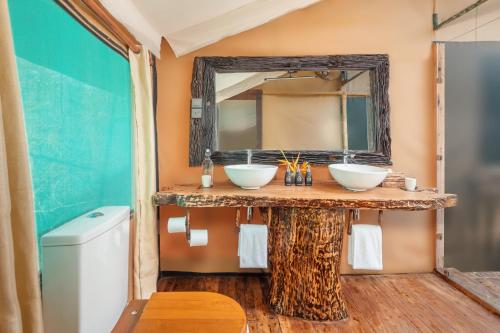 a bathroom with two sinks and a mirror at Leopard Safaris Yala in Yala