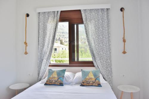 a bedroom with a bed with a window at Maria Apartments in Lourdhata