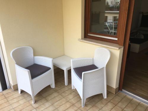 three white chairs and a table in a room at LaSiesta Merano in Merano