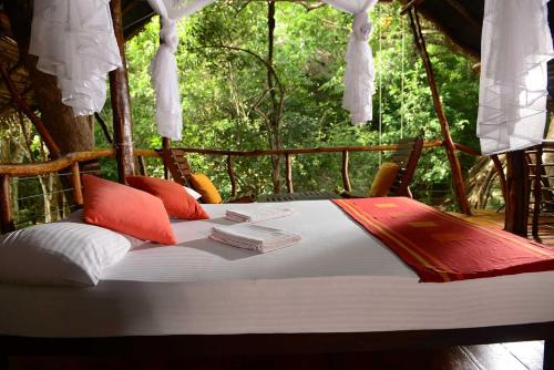 a bed in a tent with books on it at Back of Beyond - Pidurangala in Sigiriya