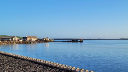 a large body of water with a pier and buildings at VitaVer, B&B, STL-OR00012F in Orkney