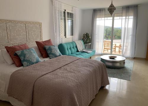 a bedroom with a bed and a couch and a table at Stunning 3 bedroom villa near Pinoso 