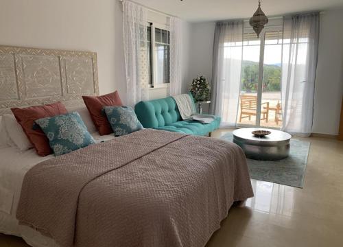 a bedroom with a bed and a couch and a table at Stunning 3 bedroom rural apartment near Pinoso in Las Encebras