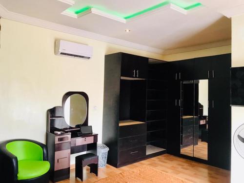 ein Ankleidezimmer mit einem Spiegel und einem grünen Stuhl in der Unterkunft Harmony Homes Ibadan: Modern 3BR Duplex in Oluyole in Ibadan