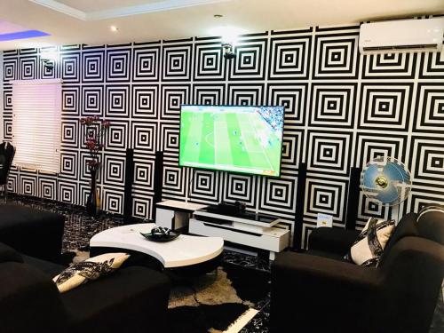 ein Wohnzimmer mit einem Flachbild-TV an der Wand in der Unterkunft Harmony Homes Ibadan: Modern 3BR Duplex in Oluyole in Ibadan