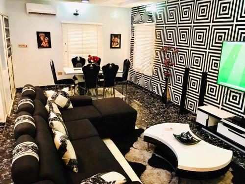 a living room with a couch and a tv at Harmony Homes Ibadan: Modern 3BR Duplex in Oluyole in Ibadan