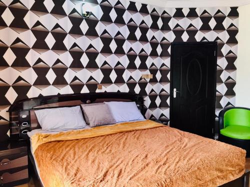 a bedroom with a bed and a black and white wall at Harmony Homes Ibadan: Modern 3BR Duplex in Oluyole in Ibadan
