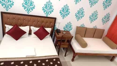 a room with two beds and a chair and a table at VILLA DE SRIVAARI RESIDENCY in Puducherry